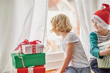 simsearch:614-05819070,k - Christmas morning in a family home. A girl on a window seat looking out. Stock Photo - Premium Royalty-Free, Code: 6118-08521738