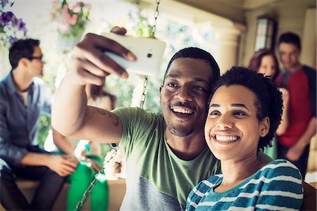 A group of friends, men and women at a house party. A couple taking a selfie. Photographie de stock - Premium Libres de Droits, Code: 6118-08521893