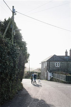 simsearch:6118-07731935,k - Two women walking along a village street with a dog on a lead. Stock Photo - Premium Royalty-Free, Code: 6118-08521835