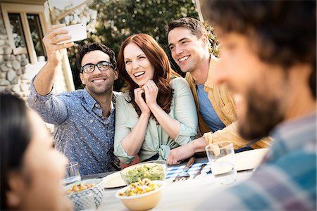 sinceridad - Two men and a woman taking a selfie with a smart phone. Foto de stock - Sin royalties Premium, Código: 6118-08521923