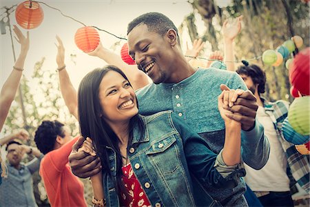 A group of men and women at a party dancing outdoors. Stock Photo - Premium Royalty-Free, Code: 6118-08521931