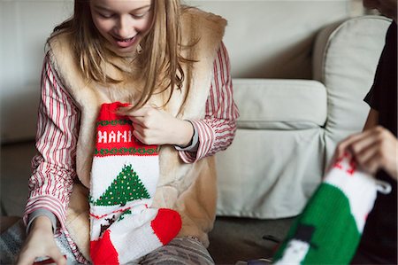 Two people unwrapping Christmas stocking presents on Christmas morning. Foto de stock - Sin royalties Premium, Código: 6118-08659703