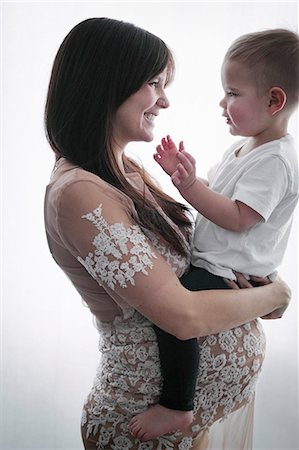 simsearch:6118-08659802,k - A pregnant woman holding her young son in her arms. Stock Photo - Premium Royalty-Free, Code: 6118-08659800