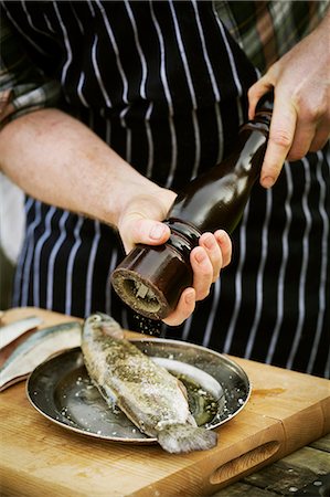 Chef using a salt mill, grinding salt onto a fresh fish. Foto de stock - Sin royalties Premium, Código: 6118-08660070