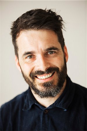 england men shirt - Portrait of a bearded man smiling at the camera. Stock Photo - Premium Royalty-Free, Code: 6118-08660032