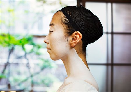 A modern geisha or maiko woman in traditional fashion, with white face makeup. Profile. Photographie de stock - Premium Libres de Droits, Code: 6118-08761727