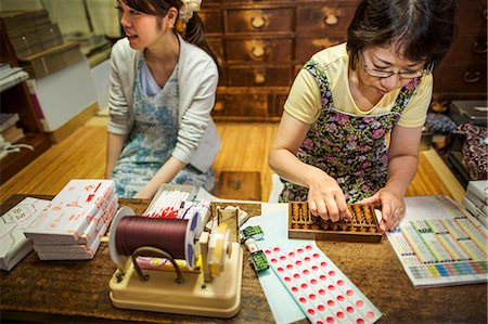 A small artisan producer of specialist treats, sweets called wagashi. Two women working packing sweet boxes for delivery. Stock Photo - Premium Royalty-Free, Code: 6118-08761858