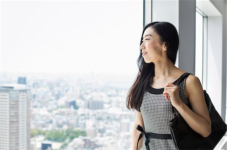 A business woman by a window with a view over the city, Photographie de stock - Premium Libres de Droits, Code: 6118-08761815