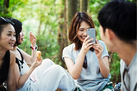 simsearch:6118-08762190,k - Three young women and a man sitting in a forest. Foto de stock - Royalty Free Premium, Número: 6118-08761950