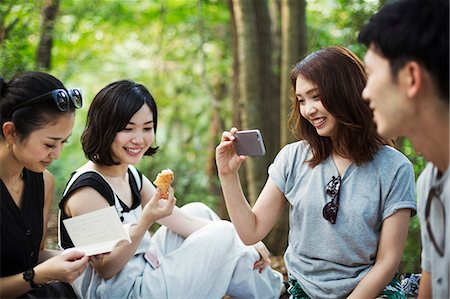 simsearch:6118-08762190,k - Three young women and a man sitting in a forest. Foto de stock - Royalty Free Premium, Número: 6118-08761951