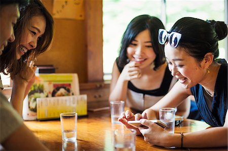 simsearch:6118-08762190,k - Three young women and a man sitting in a cafe. Foto de stock - Royalty Free Premium, Número: 6118-08761973