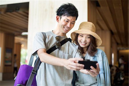 simsearch:6118-08762190,k - Young woman and man standing outdoors, taking selfie. Foto de stock - Royalty Free Premium, Número: 6118-08761972