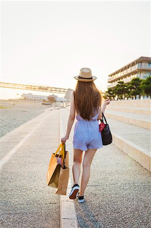 simsearch:6118-07813281,k - Young woman with long brown hair, wearing Panama hat and carrying shopping bags. Stock Photo - Premium Royalty-Free, Code: 6118-08762069