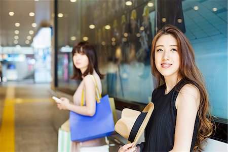 simsearch:6118-07813281,k - Two young women with long brown hair in a shopping centre. Stock Photo - Premium Royalty-Free, Code: 6118-08762079