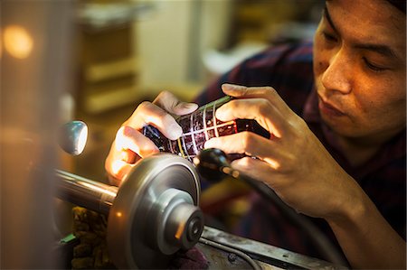 simsearch:6118-09200406,k - A craftsman at work at a machine, etching or scoring a coloured glass object. Foto de stock - Sin royalties Premium, Código: 6118-08762097
