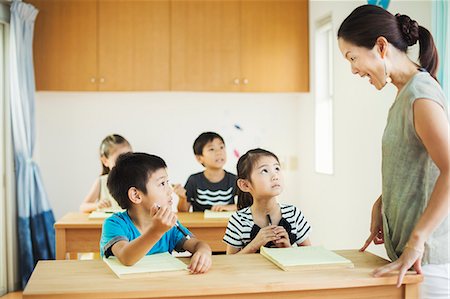 simsearch:6118-09079486,k - A group of children in a classroom with their female teacher. Foto de stock - Royalty Free Premium, Número: 6118-08762149