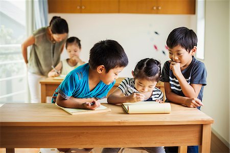 simsearch:6118-09079486,k - A group of children in a classroom with their female teacher. Foto de stock - Royalty Free Premium, Número: 6118-08762154