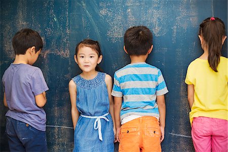 A group of children in school. Four children standing by the blackboard. Stock Photo - Premium Royalty-Free, Code: 6118-08762168