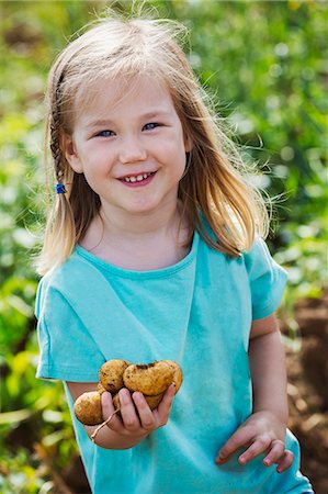 simsearch:6118-08797549,k - A girl holding potatoes in a vegetable patch. Photographie de stock - Premium Libres de Droits, Code: 6118-08797543