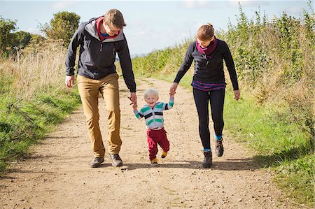 simsearch:6118-09059672,k - Parents and a child walking along a footpath in the countryside. Foto de stock - Sin royalties Premium, Código: 6118-08797644