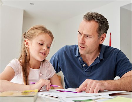 simsearch:649-03363353,k - A young girl and her father sitting looking at her school books, doing her homework. Stockbilder - Premium RF Lizenzfrei, Bildnummer: 6118-08797614