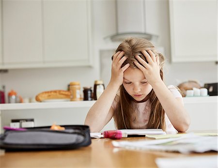 simsearch:649-03363353,k - A girl sitting at a table with her hands on her head, looking at her homework. Stockbilder - Premium RF Lizenzfrei, Bildnummer: 6118-08797619