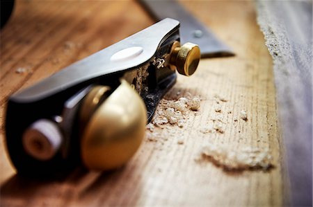 A furniture workshop making bespoke contemporary furniture pieces using traditional skills in modern design. A wood plane with smooth handle and wood shavings. Stock Photo - Premium Royalty-Free, Code: 6118-08725448