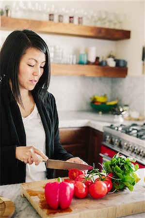 simsearch:6118-07439839,k - A woman using a sharp knife, slicing tomatoes. Photographie de stock - Premium Libres de Droits, Code: 6118-08725475