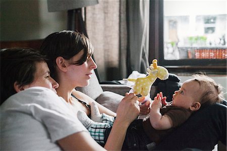 A same sex couple, two women playing with their 6 month old baby girl. Stock Photo - Premium Royalty-Free, Code: 6118-08725496