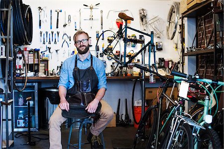 simsearch:6118-08725915,k - A man working in a bicycle repair shop. Fotografie stock - Premium Royalty-Free, Codice: 6118-08725690