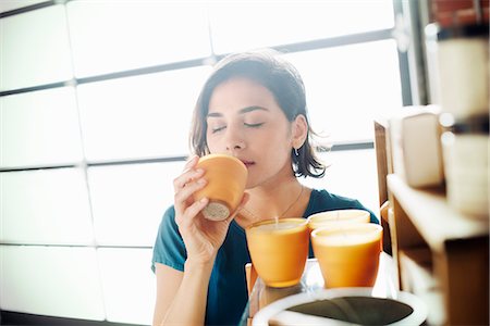 ethnic indian women - Young woman in a shop, smelling a scented candle. Stock Photo - Premium Royalty-Free, Code: 6118-08725741