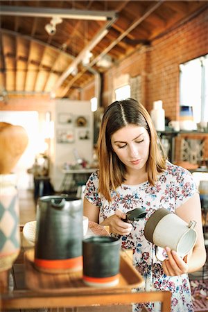 simsearch:6118-07440349,k - Young woman in a shop, scanning the barcode of a ceramic jug with a barcode scanner. Stock Photo - Premium Royalty-Free, Code: 6118-08725719