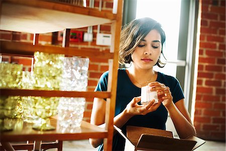 southern california - Young woman in a shop, holding a small ceramic object. Photographie de stock - Premium Libres de Droits, Code: 6118-08725737