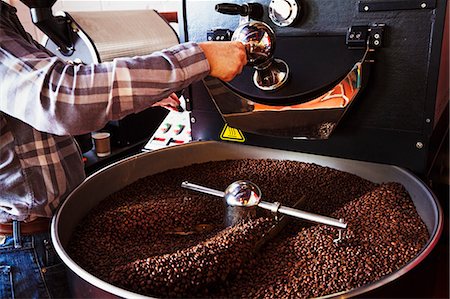 simsearch:6118-07353041,k - Specialist coffee shop. Coffee beans roasting in a drum, being stirred with a metal paddle. Photographie de stock - Premium Libres de Droits, Code: 6118-08725864