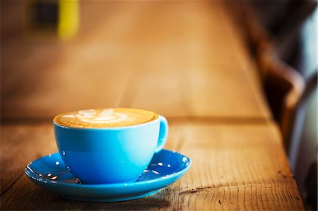 Specialist coffee shop. A blue china cup and saucer with frothy coffee. Photographie de stock - Premium Libres de Droits, Code: 6118-08725869