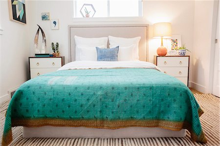 A bedroom in an apartment with a double bed and beside cabinets, and a green checked patterned bed cover. Fotografie stock - Premium Royalty-Free, Codice: 6118-08725839