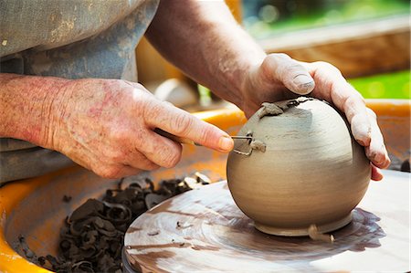 A woman potter working clay on a potter's wheel in her workshop. Stockbilder - Premium RF Lizenzfrei, Bildnummer: 6118-08725943