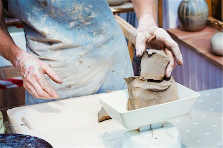 A woman potter working clay measuring it on a weighing scale. Stockbilder - Premium RF Lizenzfrei, Bildnummer: 6118-08725955