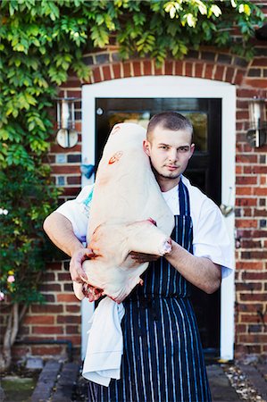 The Red Lion village public house chef carrying a large carcass of an animal, meat for the restaurant. Stock Photo - Premium Royalty-Free, Code: 6118-08725924