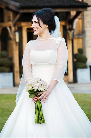 simsearch:6118-07521749,k - A bride in her wedding dress carrying a bouquet. Photographie de stock - Premium Libres de Droits, Code: 6118-08726045