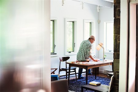 simsearch:6118-08282226,k - A man at home using a laptop on a desk. Photographie de stock - Premium Libres de Droits, Code: 6118-08726103