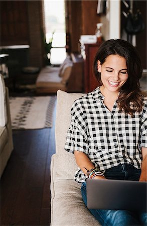 simsearch:614-06897565,k - Woman with long brown hair lying on a sofa, using a laptop computer. Stock Photo - Premium Royalty-Free, Code: 6118-08729163