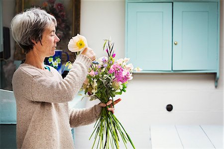 A florist creating a hand tied bunch of fresh flowers. Photographie de stock - Premium Libres de Droits, Code: 6118-08729182