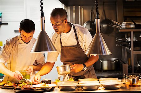 food on plate restaurant - Two chefs standing in a restaurant kitchen, plating food. Stock Photo - Premium Royalty-Free, Code: 6118-08729221