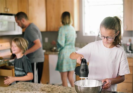 simsearch:6118-09079278,k - Family preparing breakfast in a kitchen. Fotografie stock - Premium Royalty-Free, Codice: 6118-08729301