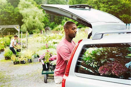 Car parked at a garden centre, man loading flowers into the boot. Stock Photo - Premium Royalty-Free, Code: 6118-08729334