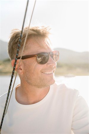 simsearch:6118-07352544,k - Portrait of a blond man with sunglasses on a sail boat. Stock Photo - Premium Royalty-Free, Code: 6118-08729426