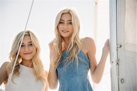 Portrait of two blond sisters on a sail boat. Stock Photo - Premium Royalty-Free, Code: 6118-08729434