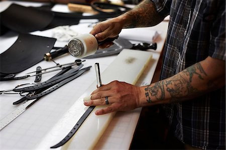 simsearch:6118-08088592,k - A man working at a bench in a leather workshop, using a mallet and chisel to mark leather. Fotografie stock - Premium Royalty-Free, Codice: 6118-08842072