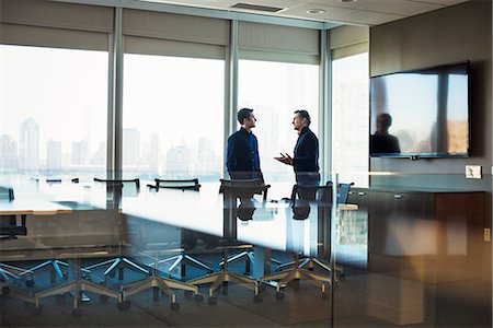 simsearch:614-08685284,k - Two men standing at a table in a meeting room talking to each other. Foto de stock - Sin royalties Premium, Código: 6118-08842166